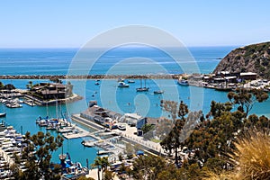 A stunning shot of the vast blue ocean water with white boats and yachts docked in the harbor and sailing in the harbor