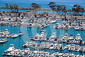 A stunning shot of the vast blue ocean water with white boats and yachts docked in the harbor and sailing in the harbor