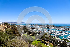 A stunning shot of the vast blue ocean water with white boats and yachts docked in the harbor and sailing in the harbor