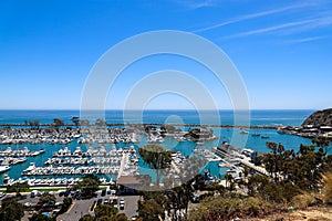 A stunning shot of the vast blue ocean water with white boats and yachts docked in the harbor and sailing in the harbor