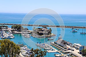 A stunning shot of the vast blue ocean water with white boats and yachts docked in the harbor and sailing in the harbor