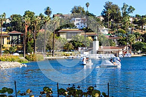 Stunning shot of the waterfall, deep blue lake water, the lush green plants in the, palm trees and people on the water