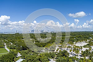 a stunning summer landscape at Crandon Park with blue ocean water, green palm trees and grass, people walking, hotels and condos