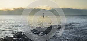 Stunning sunrise landscape over rocks in sea