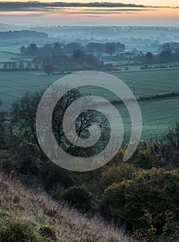 Stunning sunrise over fog layers in countryside landscape