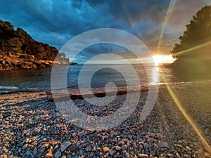 Stunning sunset over an idyllic beach a shoreline of smooth pebbles