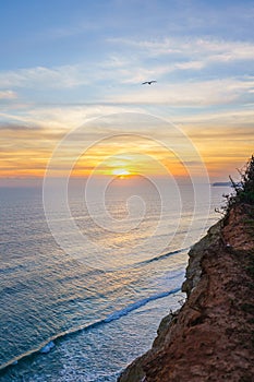 Stunning sunset over majestic cliffs with a panoramic ocean view, perfect for conveying the beauty of nature and tranquility