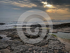 Stunning sunset view over the sea with rock platforms on the shore