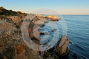 Stunning sunset view of the secluded beach and colorful cliffs. Algarve region, Portugal photo