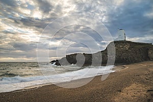 Stunning Twr Mawr lighthouse landscape from beach with dramatic