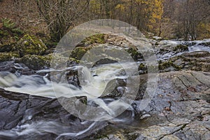 Stunning vibrant landscape image of Aira Force Upper Falls in Lake District during colorful Autumn showing