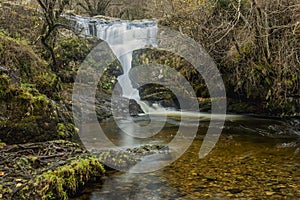 Stunning vibrant landscape image of Aira Force Upper Falls in Lake District during colorful Autumn showing