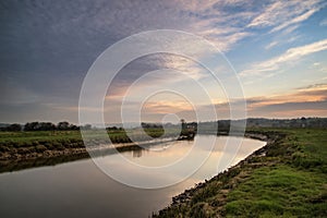 Stunning vibrant sunrise reflected in calm river