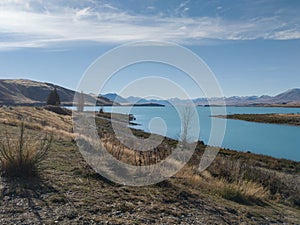 View of Lake Tekapo, New Zealand, with turquoise blue water and cloud