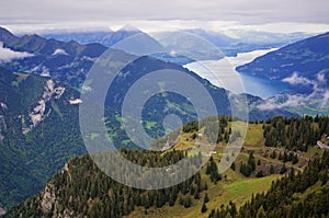 Stunning view of alpine forest, lake Brienz, mountain range and mist in Schynige Platte, Switzerland. Part of the