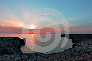 Stunning view during the sunset at rocky cliff in the ocean on menorca