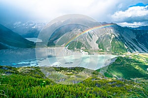 Stunning view on the high mountain after the rain with colorful rainbow over the rocky mountain and glacier in Mt Cook National