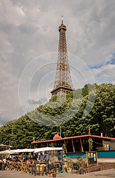 Stunning view of the iconic Eiffel Tower in Paris, France, with a quaint cafe in the foreground