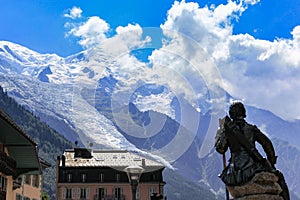 Stunning view of Mont Blanc, highest peak of Alps, from Chamonix in summer sunny day, blue sky cloud in background, statue of