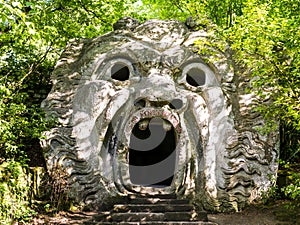 Stunning view of Orcus Mouth, a grotesque sculpture at famous Park of the Monsters, also named Sacred Grove, Bomarzo Gardens, prov photo