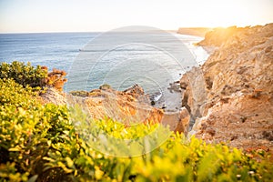 Stunning view over Praia do Camilo in Lagos, Algarve Portugal during the sunrise. Rocks, cliffs and formations in the ocean.