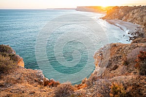 Stunning view over Praia do Camilo in Lagos, Algarve Portugal during the sunrise. Rocks, cliffs and formations in the ocean.