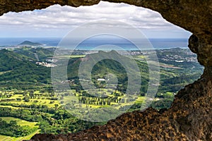 Stunning view through a rock window at the summit of famous Pali Puka hiking trail on the island of Oahu, Hawaii, USA. The dangero