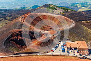 Stunning view at the volcanic crater and groups of tourists walking around it. Mount Etna, Sicily, Italy