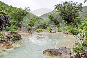 Waterfall in Ayn Khor  and Lush green landscape, trees and foggy mountains at tourist resort, Salalah, Oman photo