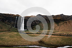 Stunning waterfall cascading into a tranquil pool of water, located in peaceful countryside setting