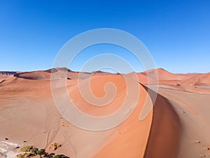 Stunning wide angle aerial drone view of a beautiful red sand dune at Sossusvlei near Sesriem in the Namib Desert of Namibia