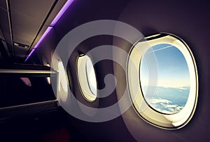 Stunning wide angle view of three airplane windows seen from a business class seat on a long haul widebody aircraft