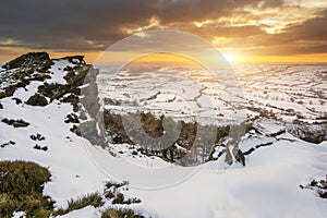 Stunning Winter sunset landscape from mountains looking over snow covered countryside