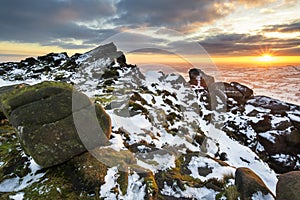 Stunning Winter sunset landscape from mountains looking over snow covered countryside