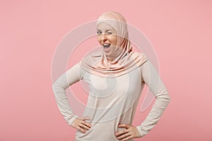 Stunning young arabian muslim girl in hijab light clothes posing isolated on pink background. People religious Islam