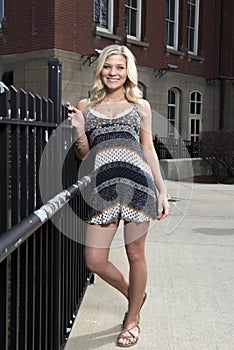 Adorable young blonde college student on campus in romper or sundress photo