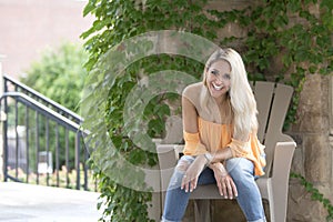 Stunning young blonde woman poses in orange blouse