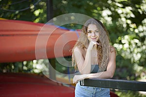 Stunning young brunette woman standing with bright canoes