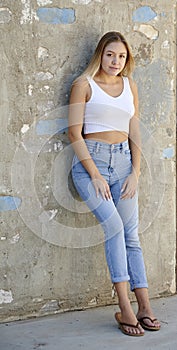 Stunning young Latina woman poses in denim and tank top