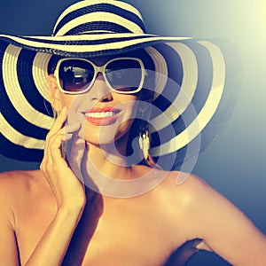 Stunning young woman in elegant hat and sunglasses