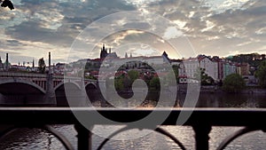 Stunningly beautiful sunset over river in midst of urban European architecture. Camera movement along forged metal fence