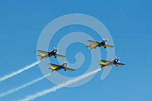 Stunt plane flying against clear blue sky.