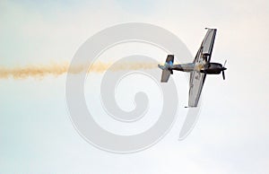 Stunt plane upside down with smoke trail.