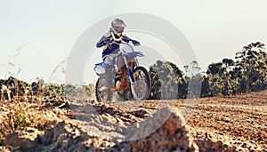 Stunt, race and man on dirt bike in desert with adventure, adrenaline and speed in competition, Extreme sport, trick and