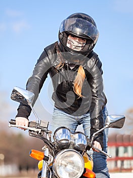Stunt rider standing on motorcycle while making trick, balancing