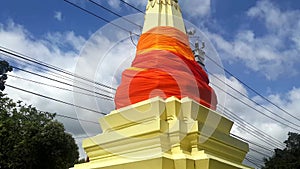 Stupa draped in fabric soars into cloudy sky