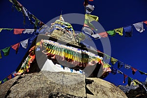 A stupa with eyes of Buddha and prayer flags in Nepalese Himalayas