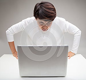 Stupefied woman staring at her laptop aghast
