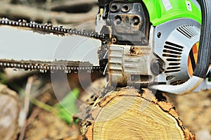 The sturdy chainsaw is lying on the stump excluded