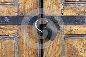 Sturdy padlock on polished wood door